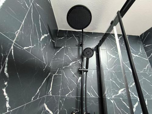 Un baño con una pared de mármol blanco y negro. en Habitaciones baratas, Cerca de la Plaza de Toros, en Alicante