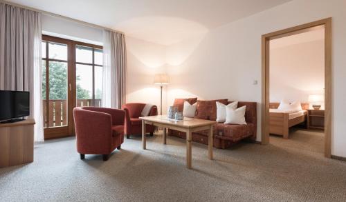 a living room with a couch and a table at Landhotel Rosenberger in Wegscheid