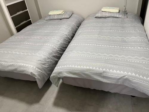 ein Bett mit zwei Kissen darauf in einem Schlafzimmer in der Unterkunft Miya's Home 102-名駅まるまる貸切メゾン in Nagoya