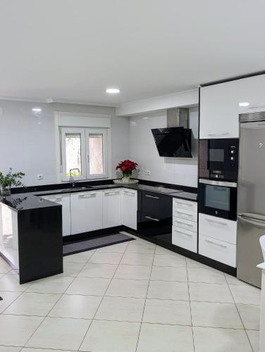 una grande cucina bianca con elettrodomestici bianchi e neri di Casa Valente a Viso