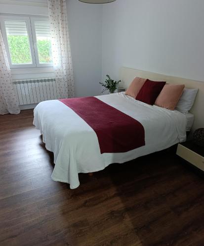 una camera da letto con un grande letto con lenzuola bianche e rosse di Casa Valente a Viso