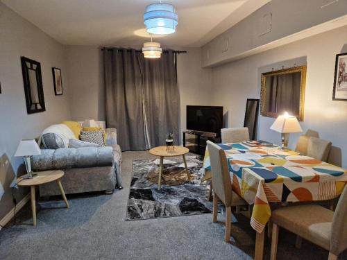 a living room with a table and a couch at Morden 2 Bed Apartment, with parking near city centre in Coventry