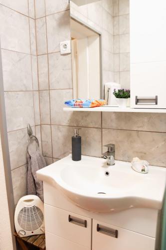 a bathroom with a white sink and a mirror at Vikend Kuća Luka in Batrovci