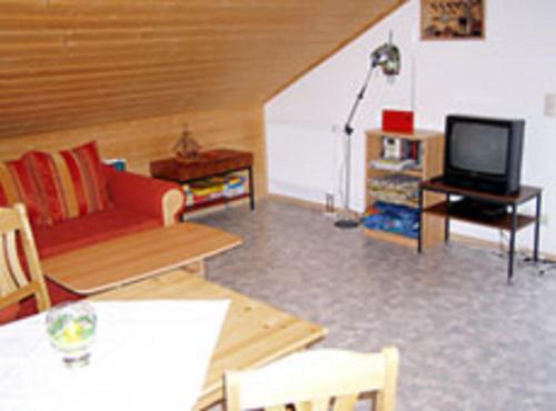 a living room with a red couch and a tv at Ferienwohnung Hernitscheck in Neuschönau