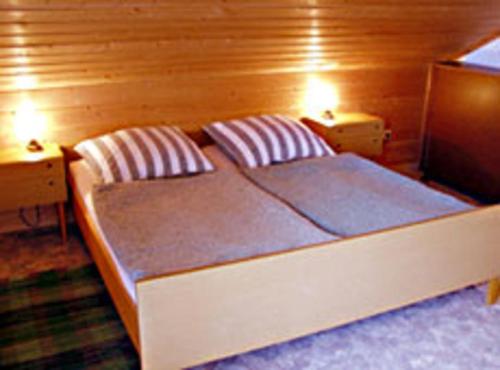 a bedroom with a bed with two lights on it at Ferienwohnung Hernitscheck in Neuschönau