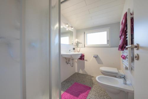 Un baño blanco con lavabo e inodoro. en Appartements Sigmair, en Valdaora