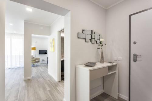 ein weißes Wohnzimmer mit einer Vase auf dem Tisch in der Unterkunft Luxury Beach Apartment at Armação de Pêra in Armação de Pêra