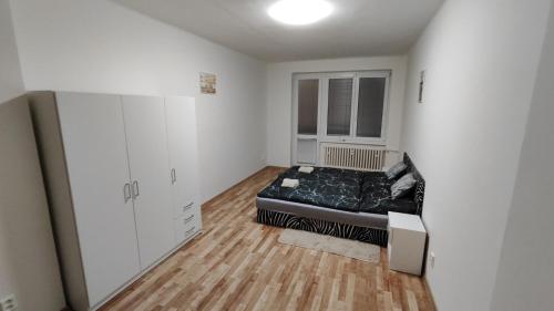 Un dormitorio con una cama en la esquina de una habitación. en Apartmán pro 4 osoby Pohraniční stráže, Kraslice, en Kraslice
