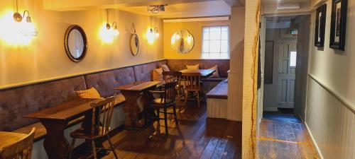 a restaurant with wooden tables and chairs and yellow walls at The Thirsty Scholar in Penryn