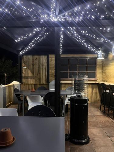 a patio with lights on a tent with tables and chairs at The Thirsty Scholar in Penryn