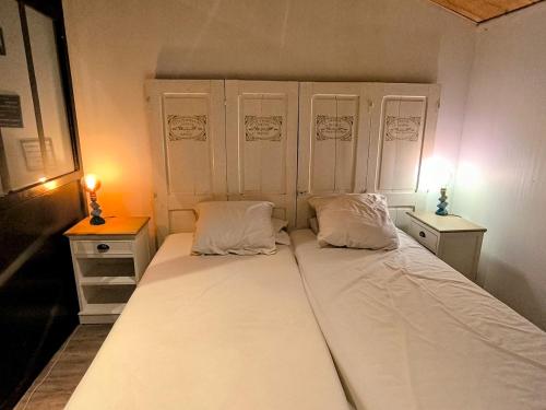 Le Dahlia - Jardin de Marie في Cerizay: سرير ابيض كبير في غرفة مع مواقف ليلتين