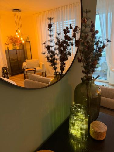 a living room with a mirror and a vase with flowers at Luxury Flat in Brno GreeN SoHo in Husovice