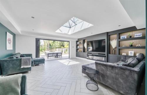 a living room with a large couch and a television at Kiwi Pines forest retreat! in Saint Leonards