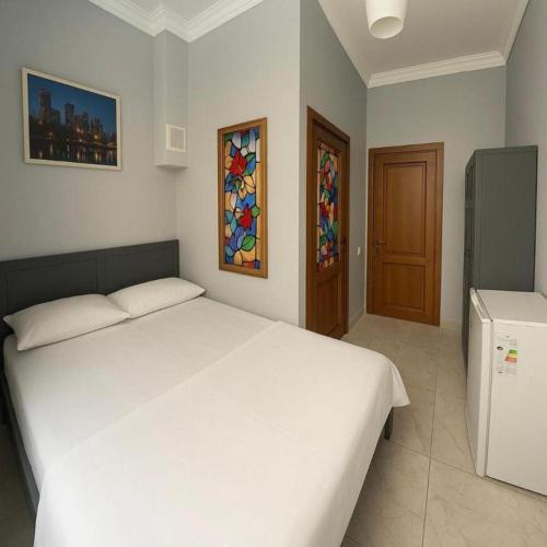 a bedroom with a large white bed and a window at Americana By California in Yerevan