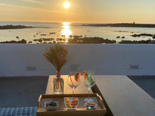 West Coast Shores في خليج جاكوبس: طاولة مع صينية طعام وغروب الشمس