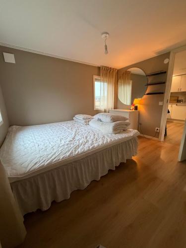 a bedroom with a bed with white blankets and pillows at Mysig stuga Buared - Family nature stay in Varberg
