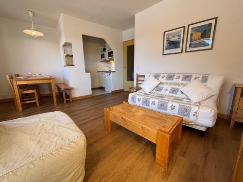 a living room with a couch and a table at Résidence Saboia Clés Blanches in La Tania