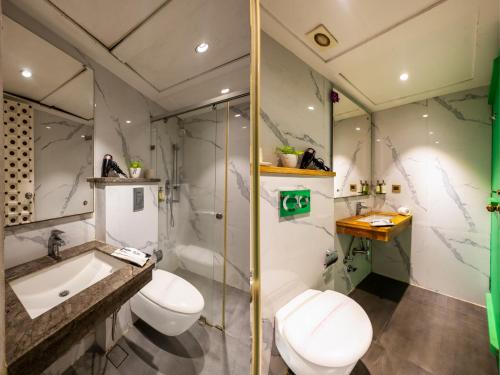 a bathroom with two toilets and a sink and a shower at Hotel Pinky Villa-Heritage Boutique Suites Near New Delhi Train station & Connaught place in New Delhi