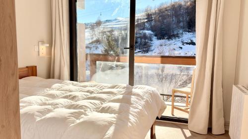 T3 Vanguard in front of ski school في Villarembert: غرفة نوم بها سرير ونافذة كبيرة