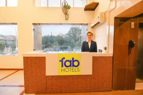 a woman standing behind a podium in an office at FabHotel Neena Palace in Bhopal