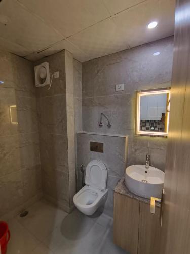 a bathroom with a toilet and a sink at Anantya Inn in Greater Noida