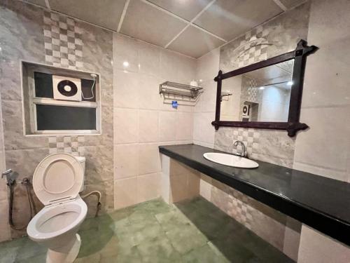 Palm Beach Resort, Alleppey في أليبي: حمام مع مرحاض ومغسلة