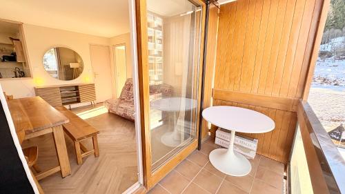 T3 Vanguard in front of ski school في Villarembert: غرفة صغيرة مع طاولة وباب زجاجي