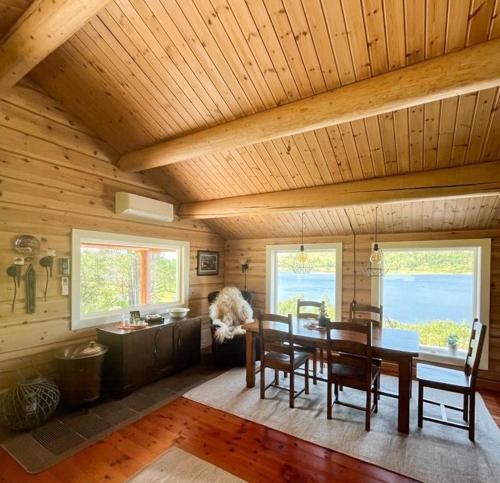 a dining room with a wooden ceiling and a table and chairs at Mountain Cabin By Hundsåvatnet With Large Veranda in Fannrem