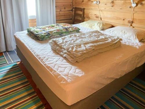 a bed with two pillows on top of it at Mountain Cabin By Hundsåvatnet With Large Veranda in Fannrem