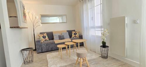 a living room with a couch and a table at T2 du Sanctuaire 400 m de la grotte Lourdes wifi TV in Lourdes