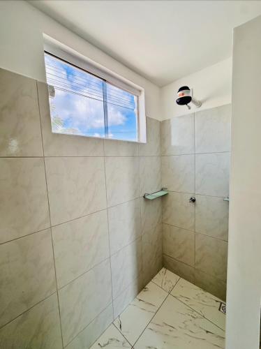 a bathroom with a shower and a window at Recanto Mar & Sol in Canguaretama