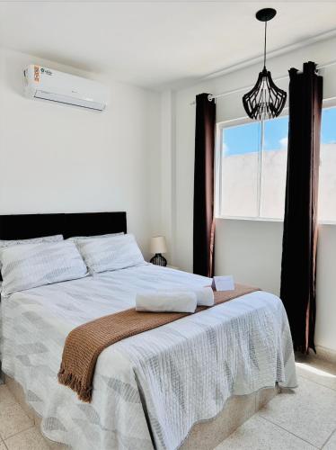 a white bedroom with a large bed with a window at Recanto Mar & Sol in Canguaretama