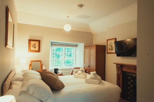 The Falcon Inn في Saint Mawgan: غرفة نوم بها سرير مع مناشف عليه