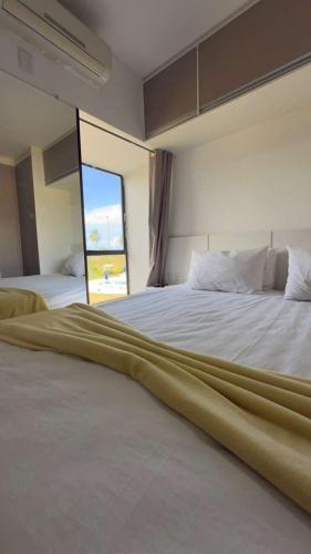 a large bed in a room with a large window at Resort Flat Gavoa in Igarassu
