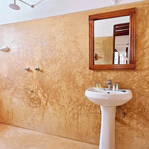 a bathroom with a sink and a mirror at AMOODY MANZIl in Shela