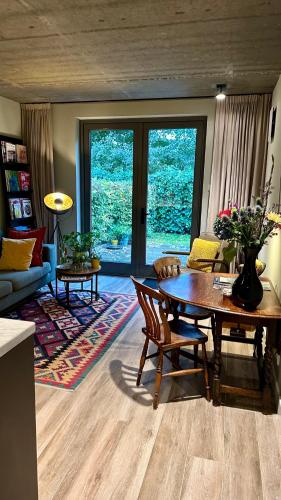 una sala de estar con una mesa y un sofá en Luxe B&B "In de Schulp", ontspan en geniet van comfort en stijl, en Amstelveen