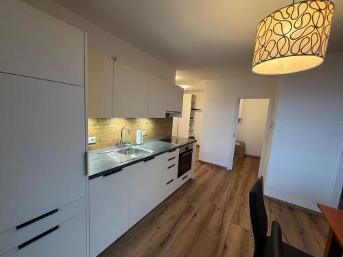 a kitchen with white cabinets and a sink at Apartment Sonnenberg in Hallein