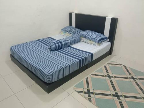 a bed with two pillows on top of it at Azizan Homestay Bahau in Bahau