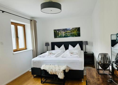 Apartment Schliersee - Stylisch, zentral, familienfreundlich في شليرزيه: غرفة نوم بسرير كبير مع لحاف أبيض