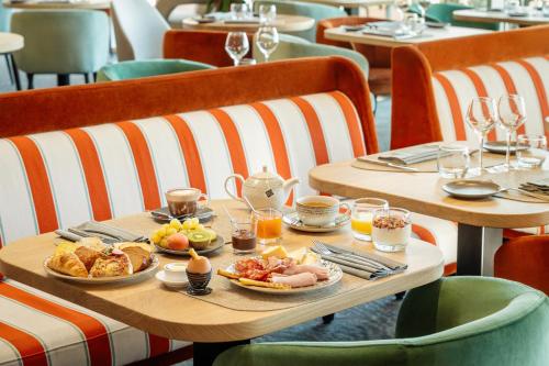 una mesa con desayuno en un restaurante en Hôtel de la Baie - Thalassothérapie PREVITHAL, en Donville-les-Bains