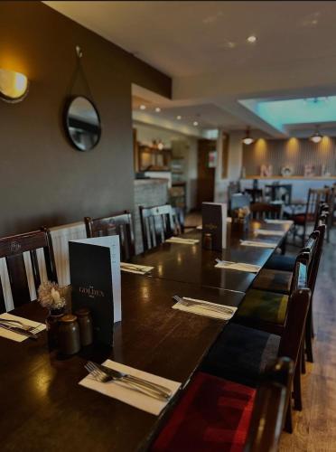 a dining room with a long table and chairs at The Golden Mile Country Inn in Ewenny