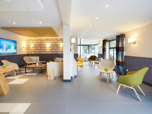 a lobby of a hotel with chairs and tables at Campanile Le Mans - Arnage in Arnage