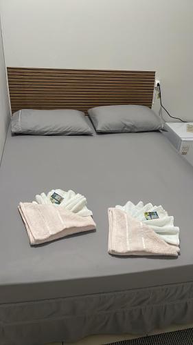 a bed with two towels sitting on top of it at Hotel Colombo in São Lourenço