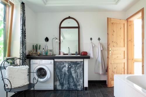 ein Badezimmer mit Waschmaschine und Spiegel in der Unterkunft Elbenow in Losenrade