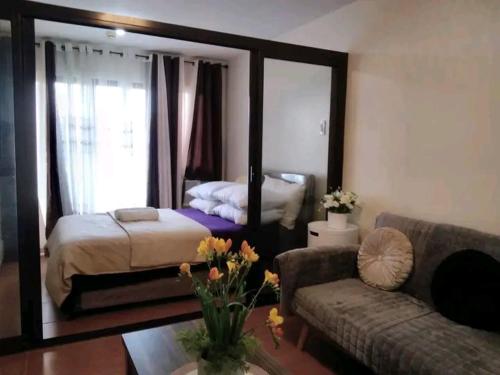 a living room with a bed and a couch and a mirror at B4B staycation one oasis cdo in Cagayan de Oro