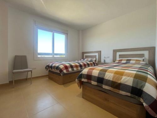 een slaapkamer met twee bedden en een raam bij Las Terrazas Golf Cédric in Torre-Pacheco