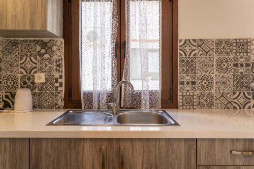 a kitchen with a sink and a window at Villa Nikos Koukounaries in Koukounaries
