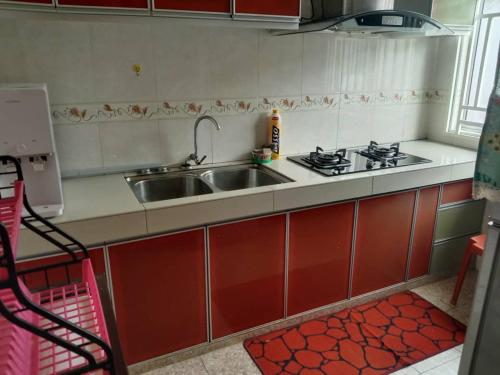 a kitchen with a sink and a stove at Azizan Homestay Bahau in Bahau