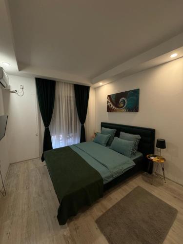 a bedroom with a large bed with a green blanket at Lucas investment L3 -104 in Creţuleasca