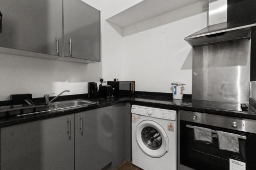a kitchen with a washing machine and a sink at Cheerful Central Studio - 2 in Leicester